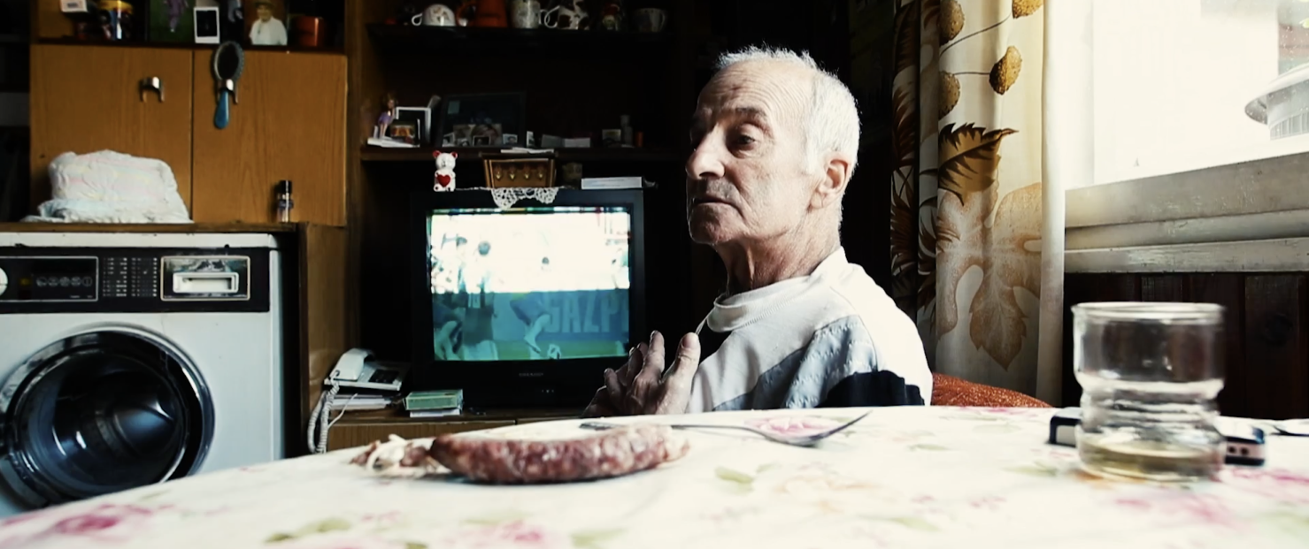 image of an elderly man sitting by a table